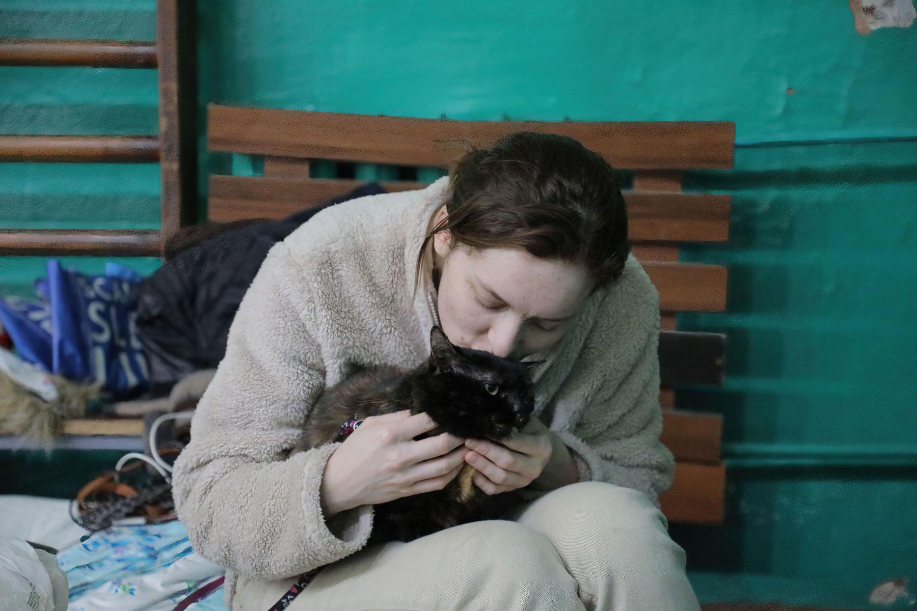 Tato žena musela utéct ze svého vybombardovaného domova. Útočiště našla i se svou kočkou v tělocvičně ve Lvově.  Zdroj: Sipa USA / Alamy Live News